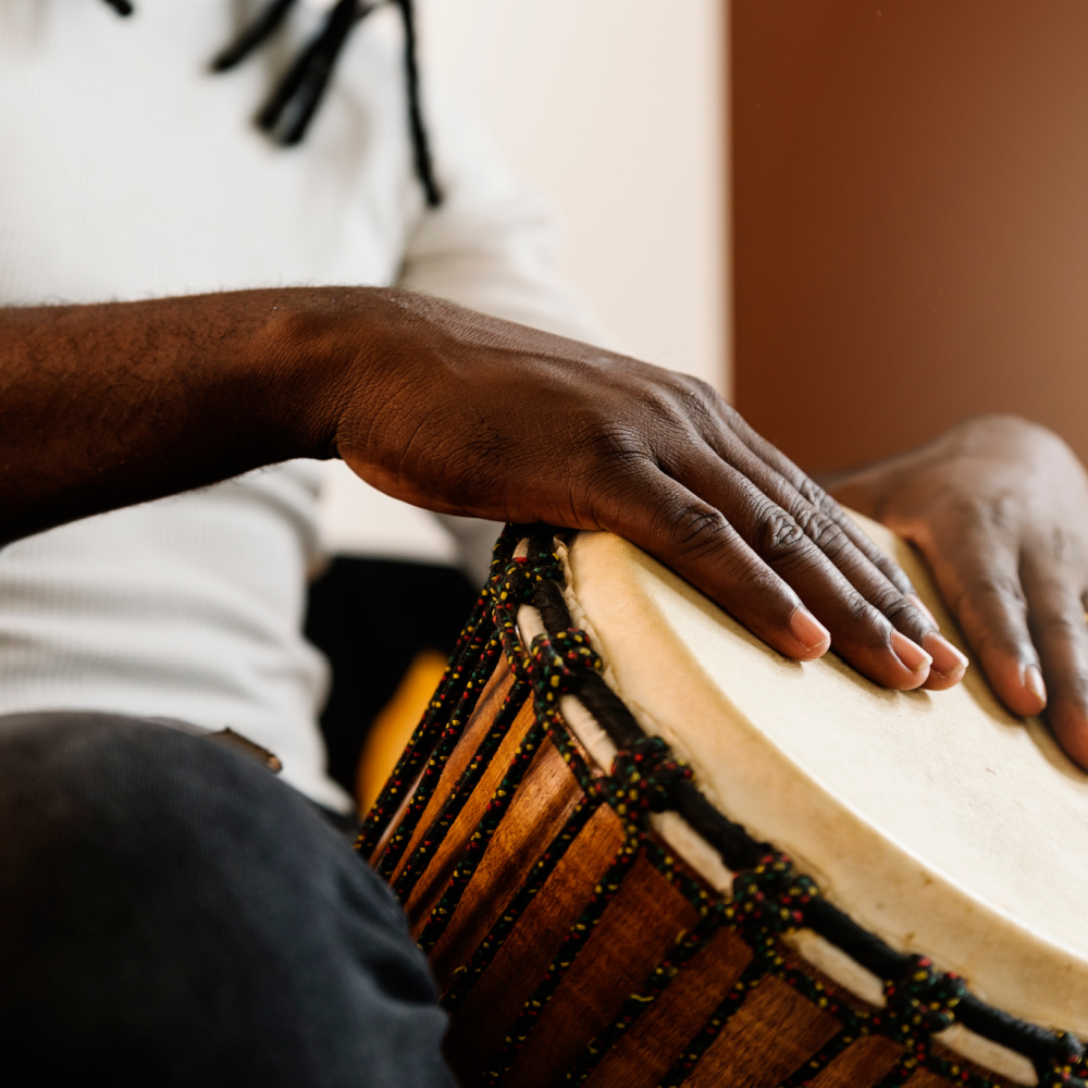 Musician playing a drum with his hands.